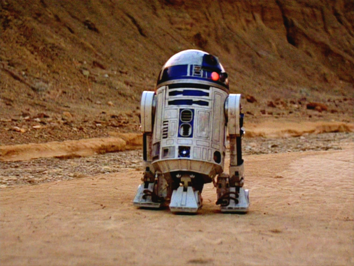 R2D2 moving across the Tatooine landscape