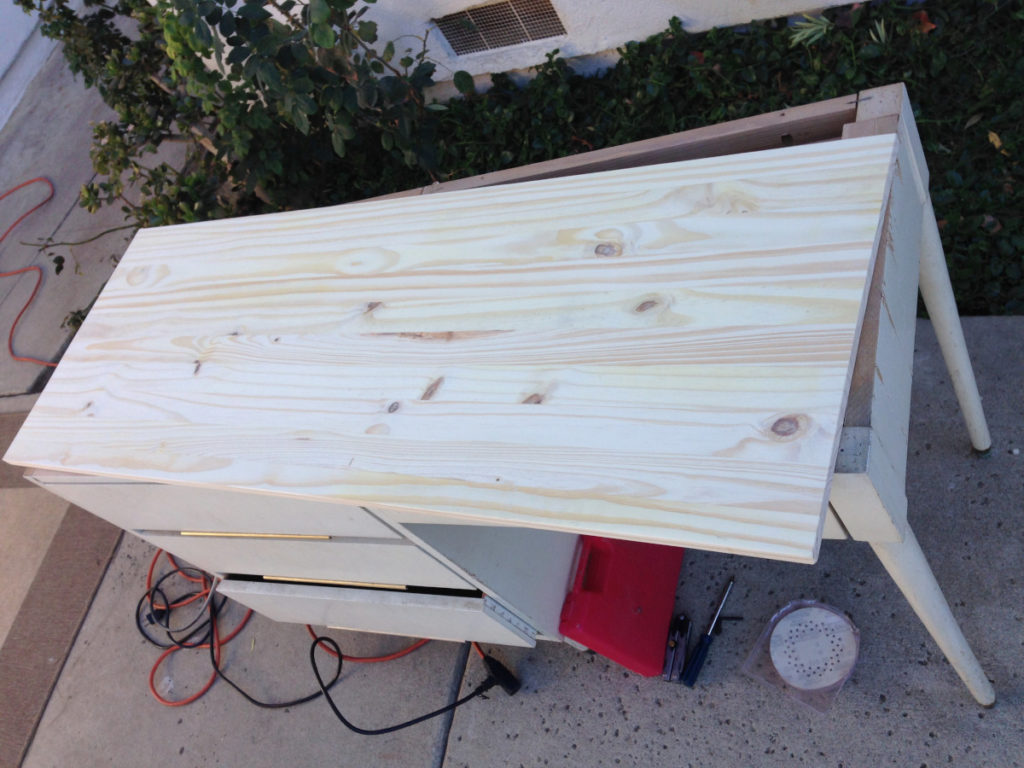 photo of desk being refurbished on a patio with tools laying around