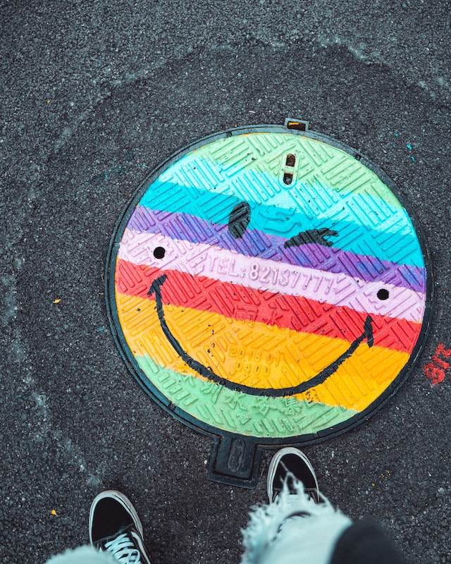 Photo of rainbow winking face manhole cover by Yuyang Liu