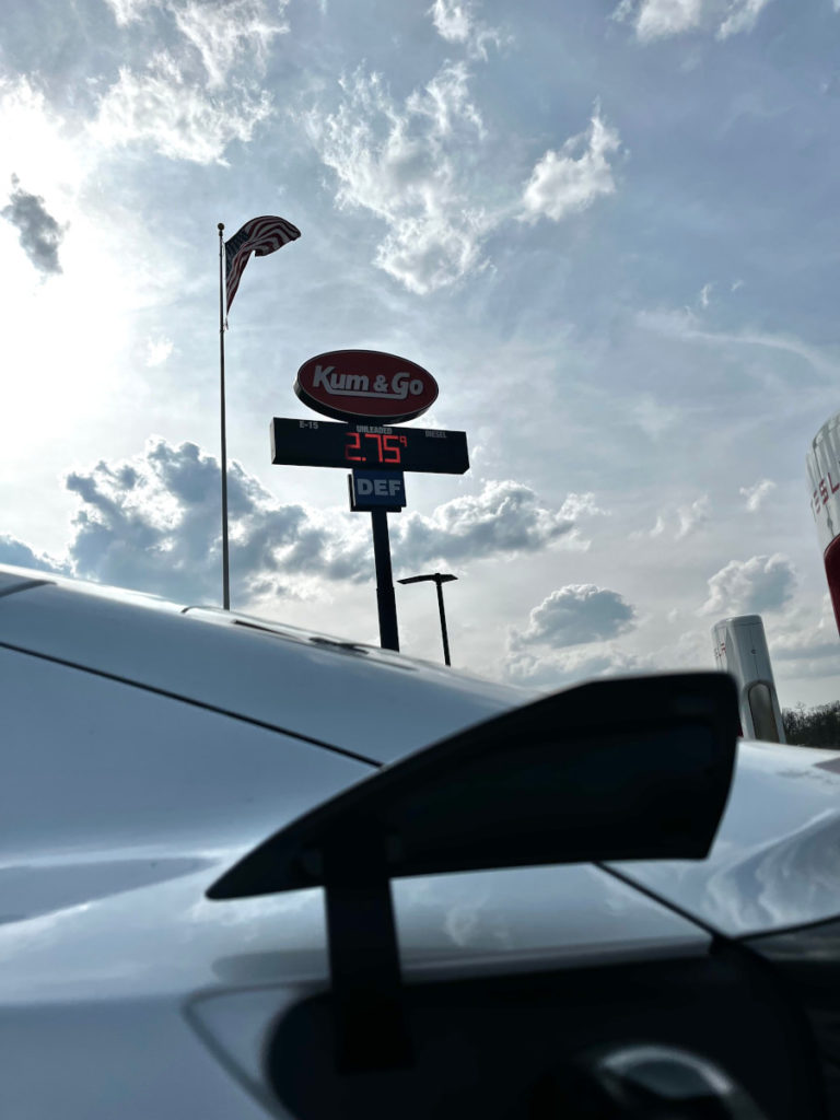 Tesla charger with Kum & Go gas statiin sign in the background