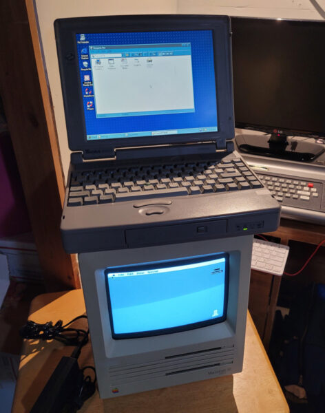 A Toshiba laptop stacked on top of a vintage Mac.